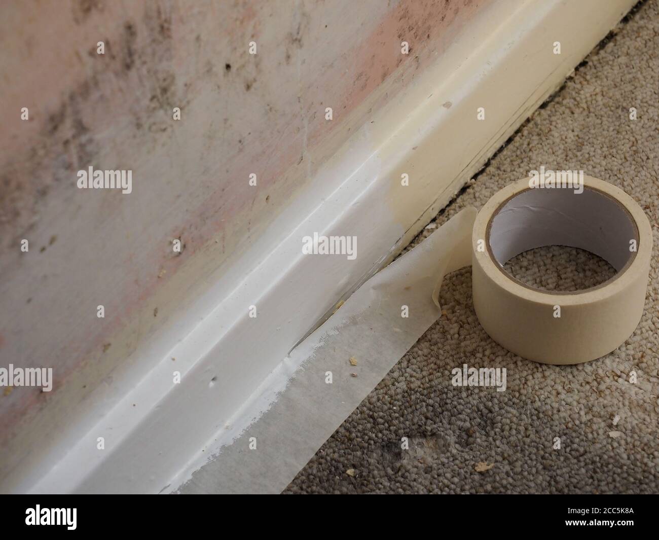 a room being decorated showing bare wall and masking tape along