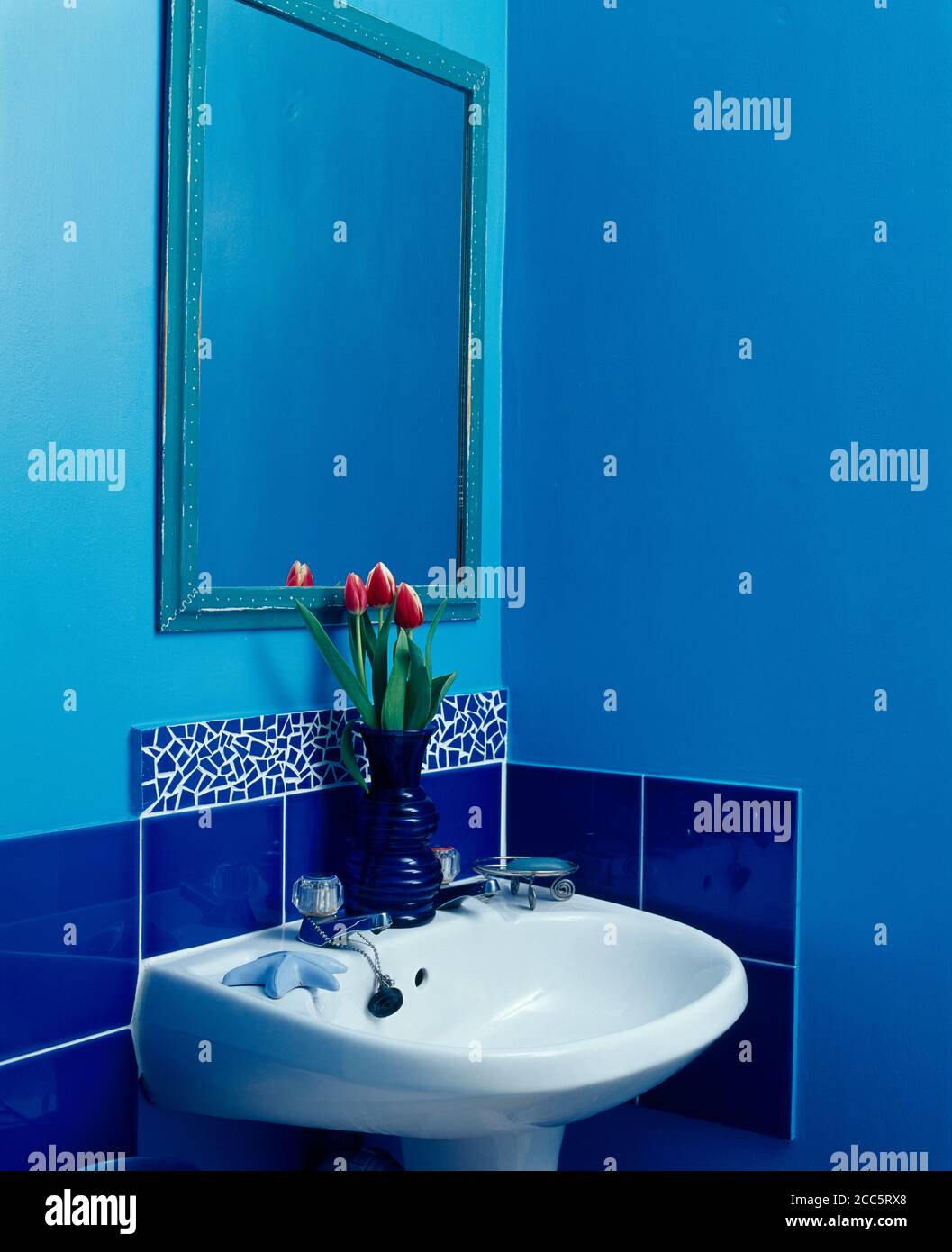 White basin in blue bathroom with blue tiles Stock Photo