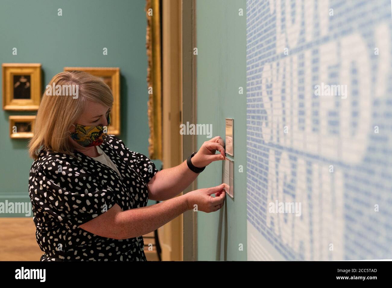 Manchester, UK. 19th Aug, 2020. Curator Fiona Corridan adjusts the label of Craig OldhamÕs Key Workers Poster as Manchester Art Gallery prepares to reopen its doors to the public on Thursday 20th August following temporary closure during the Covid-19 outbreak Credit: Russell Hart/Alamy Live News Stock Photo