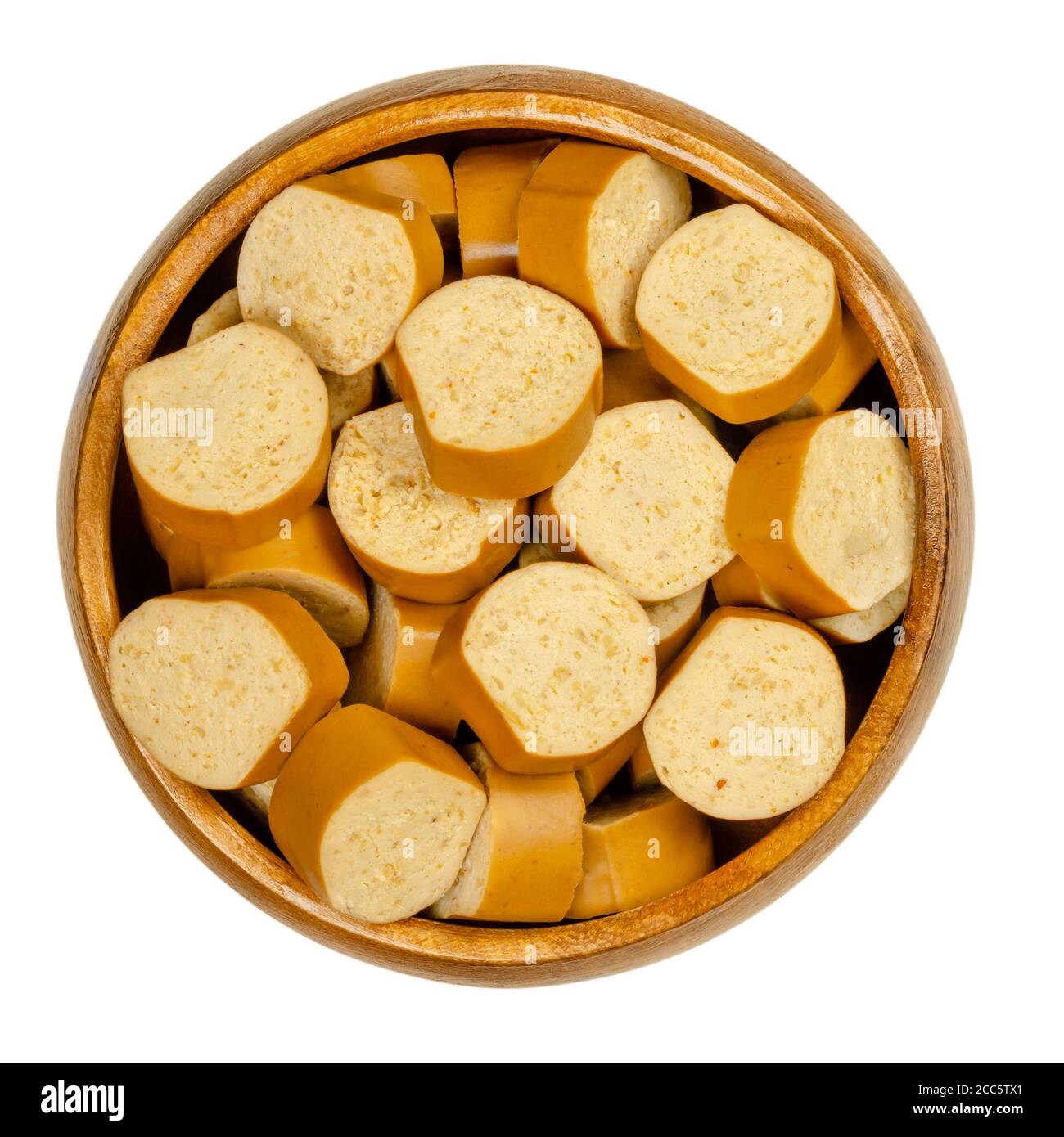 Slices of vegan Vienna sausages in a wooden bowl. Parboiled sausages, made of tofu, smoked at low temperature. Also called Wiener or Frankfurter. Stock Photo