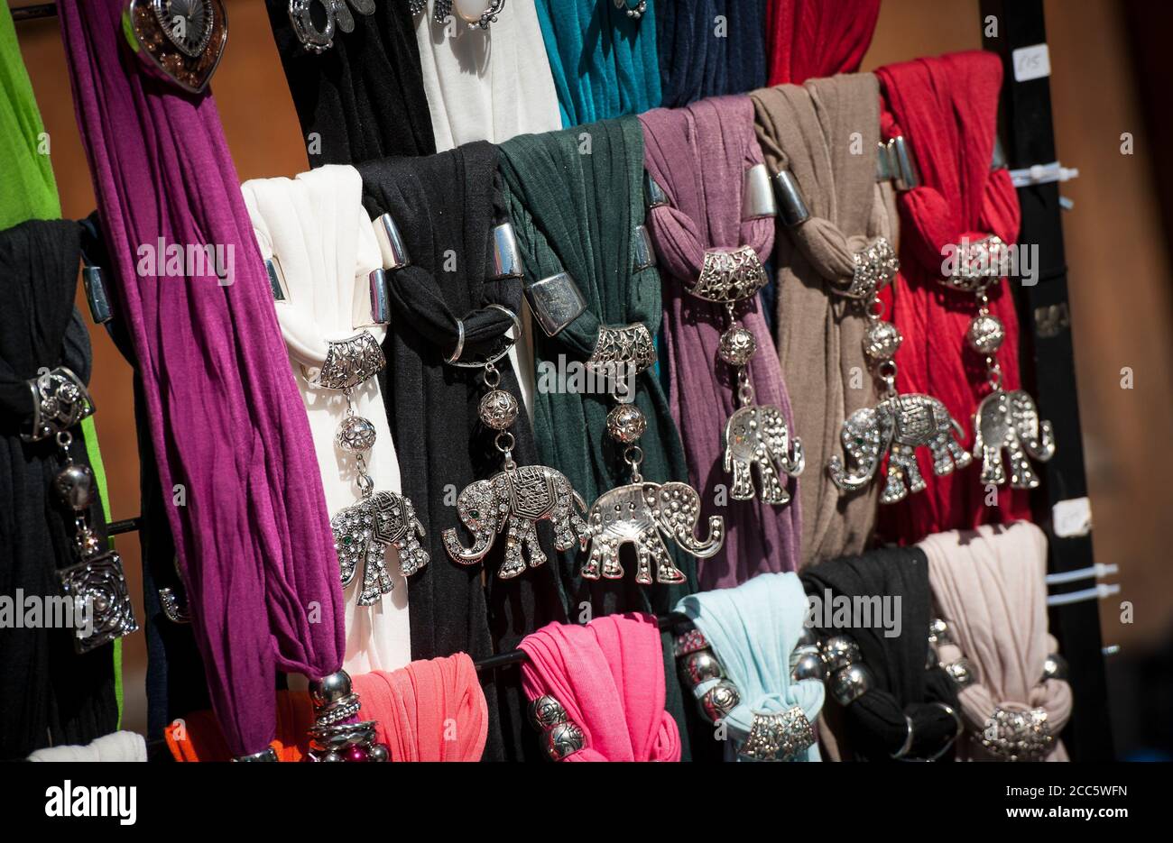 Display of scarves with elephant scarf rings for sale outside a shop. Stock Photo