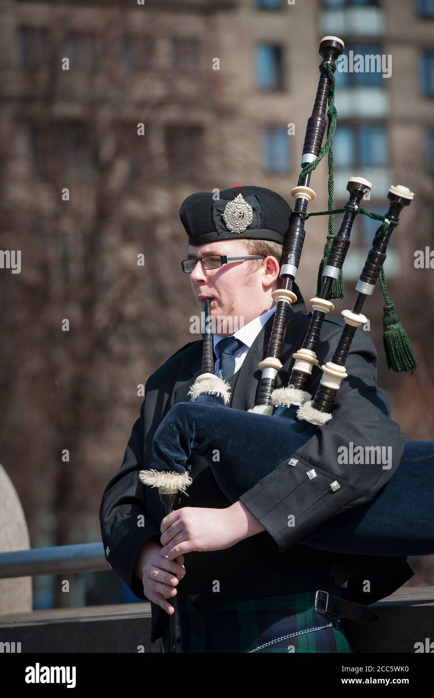 Bagpipe player dressed in traditional scottish tartan playing the bagpipes on a street in Edinburgh, Scotland. Stock Photo
