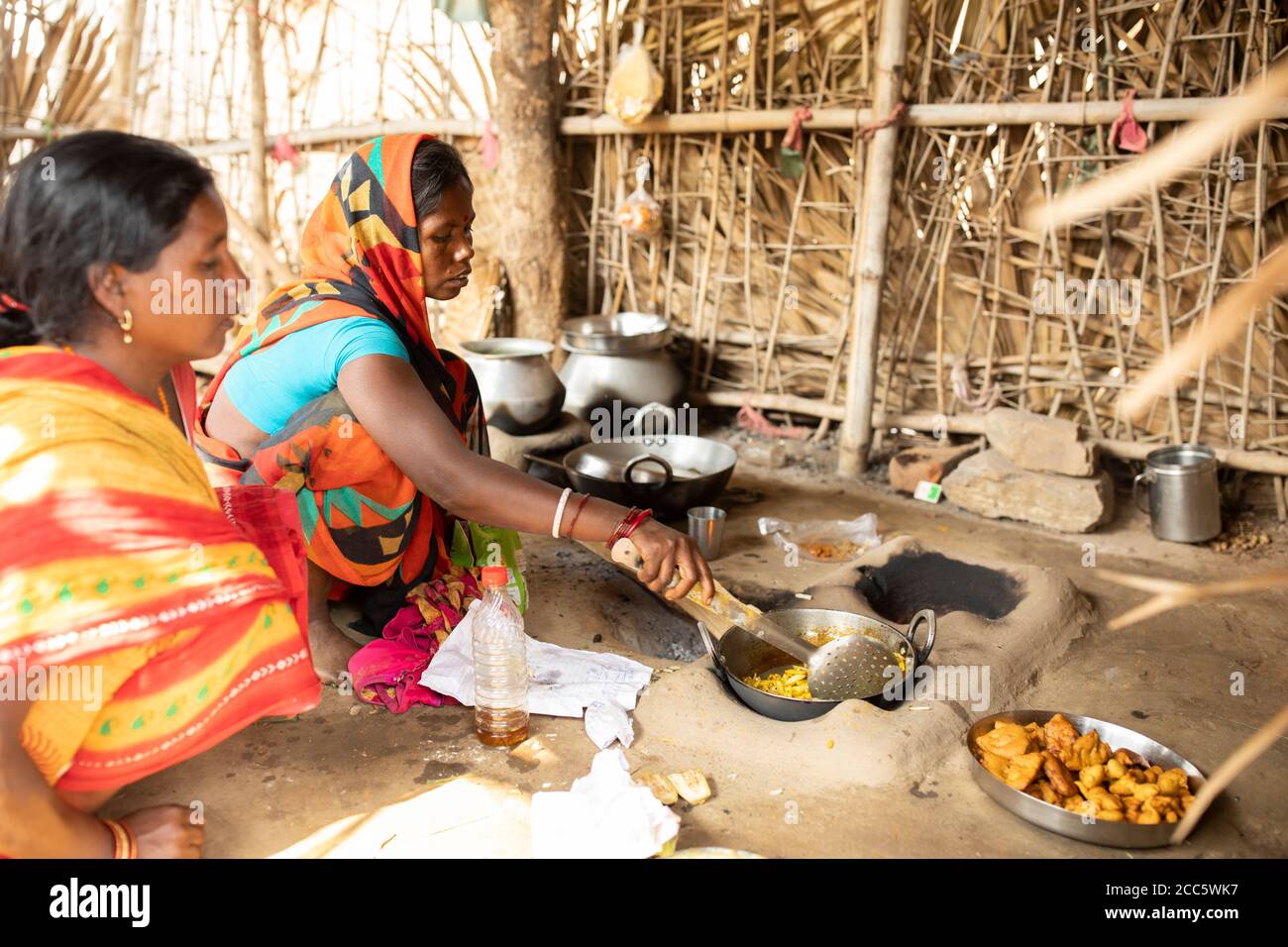 Two women cook a meal together in their village in Bihar, India. Stock Photo