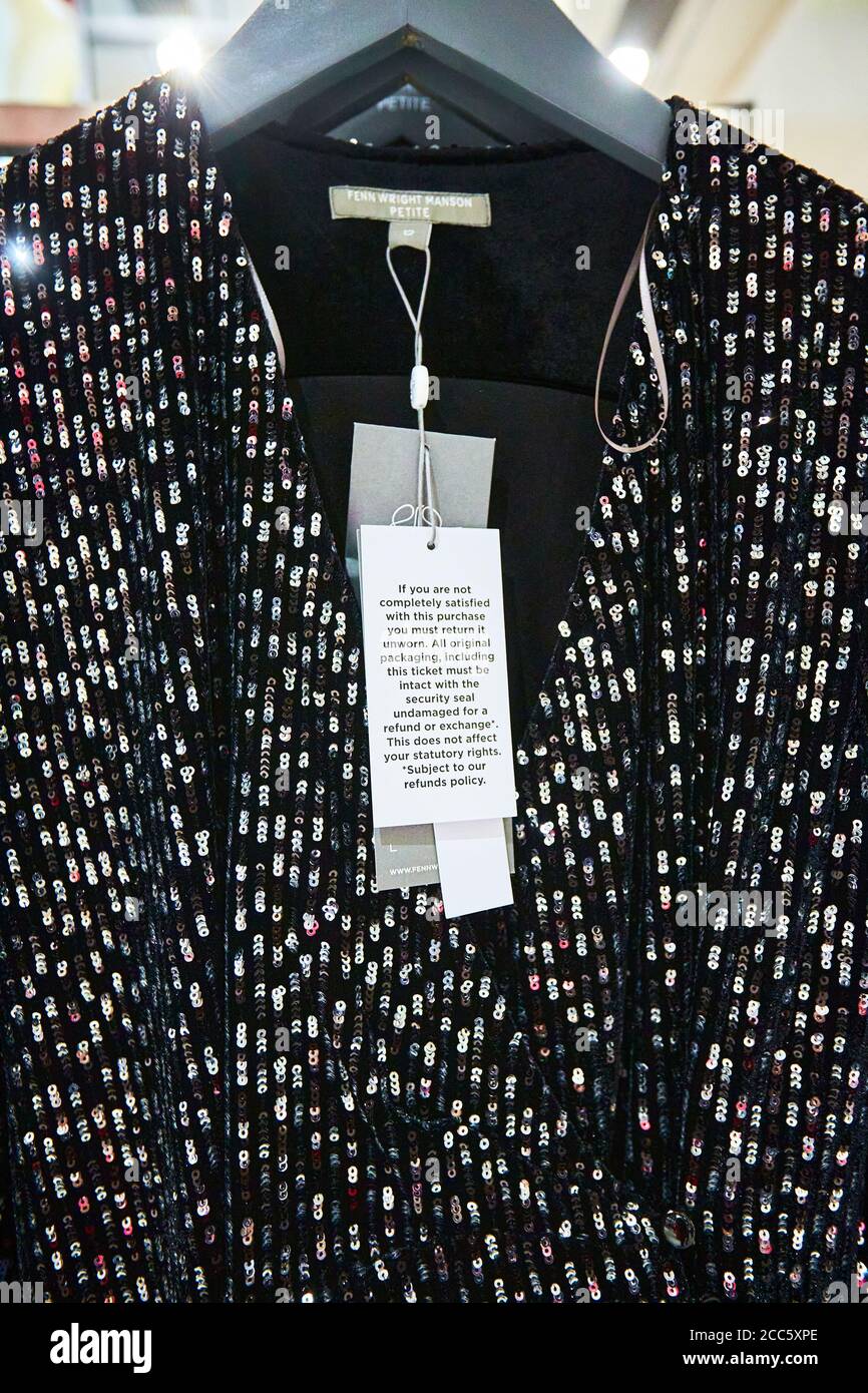 A dress by Fenn Wright Manson with a label specifying that the item must be unworn in order to quality for a refund. Fashion retailers are increasingly battling high rates of returns. Stock Photo