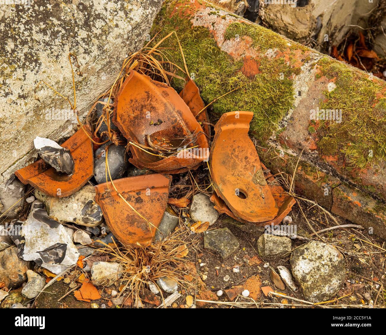Broken red clay flower pots left long forgotten in corner of garden. Gorgeous textures background Stock Photo