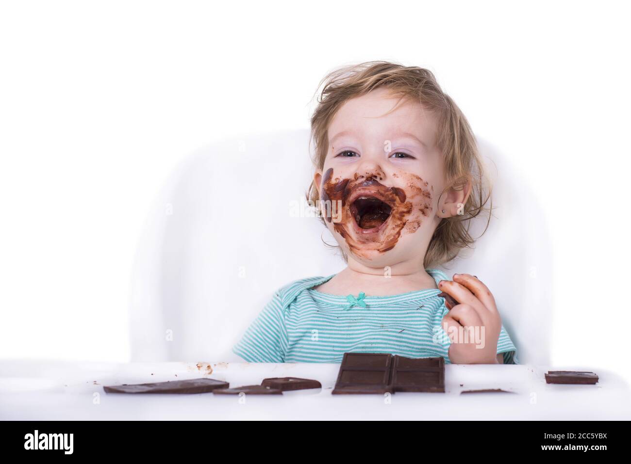 Smeared baby eating chocolate on an isolated background Stock Photo Alamy