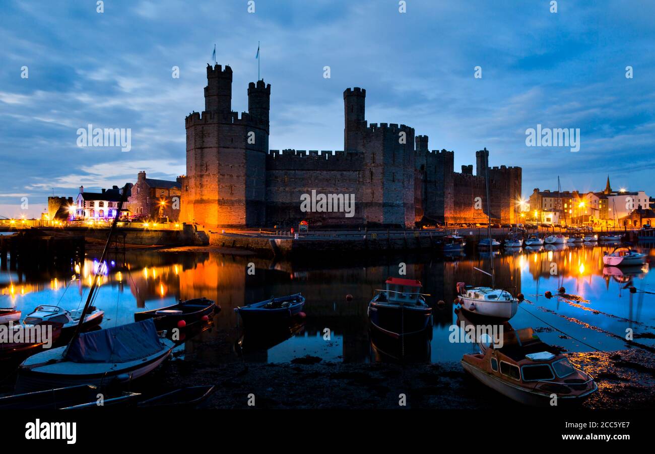 Caernarfon Castle night shot with river and boats, North Wales Stock Photo