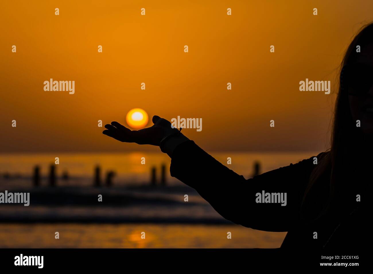Sunset over the sea. The sun in the palm of her hand Stock Photo