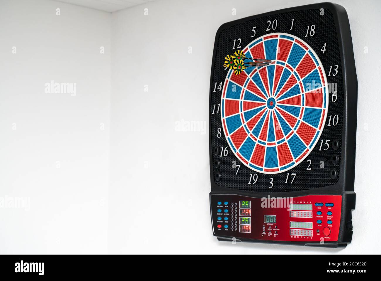 Close up of a Dart machine. In the dartboard are dart arrows. Copy Space. Stock Photo