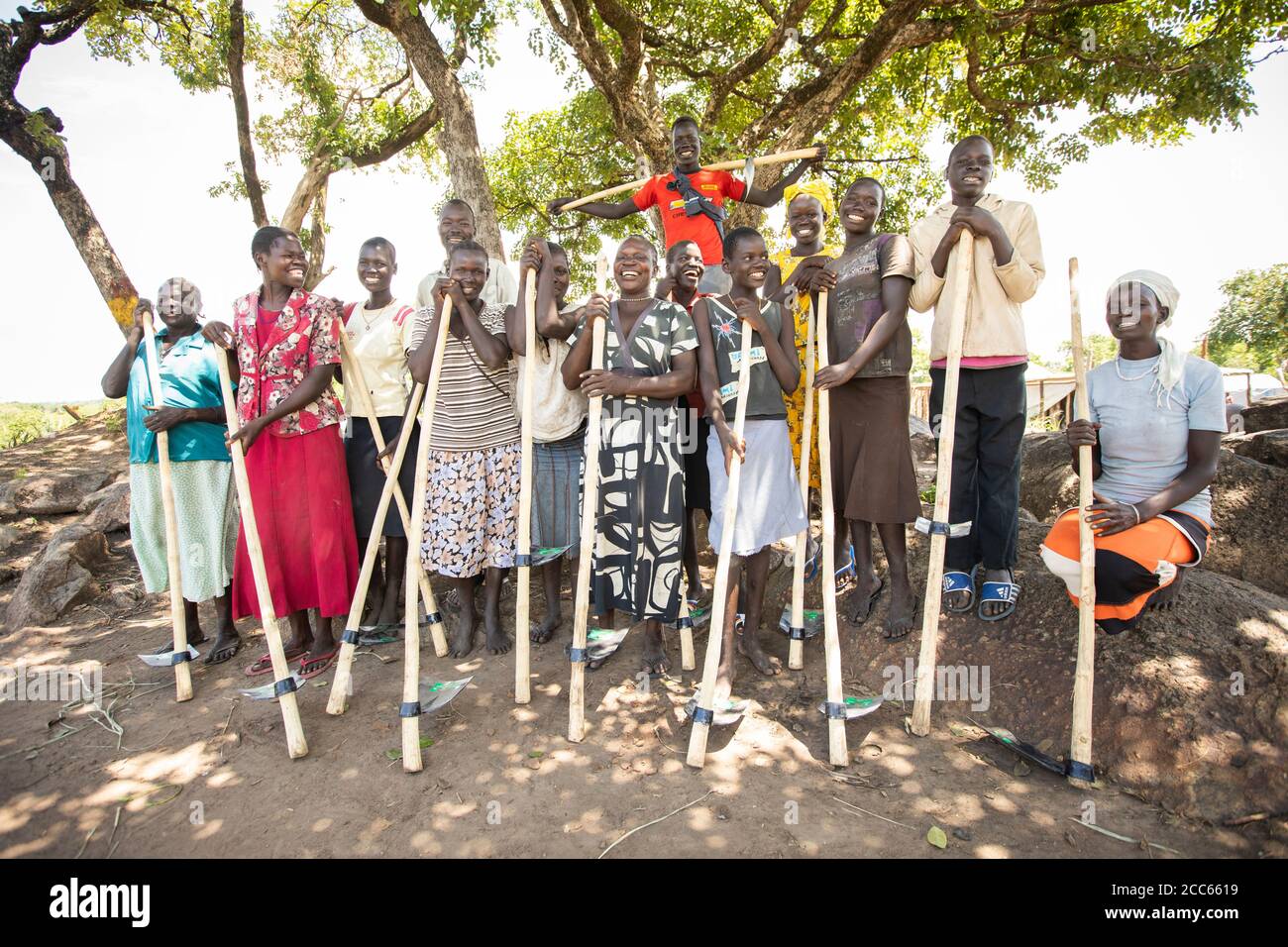 A group of farmers pose with hoes they received to help with their farming abilities in Palabek Refugee Settlement in northern Uganda, East Africa. Stock Photo