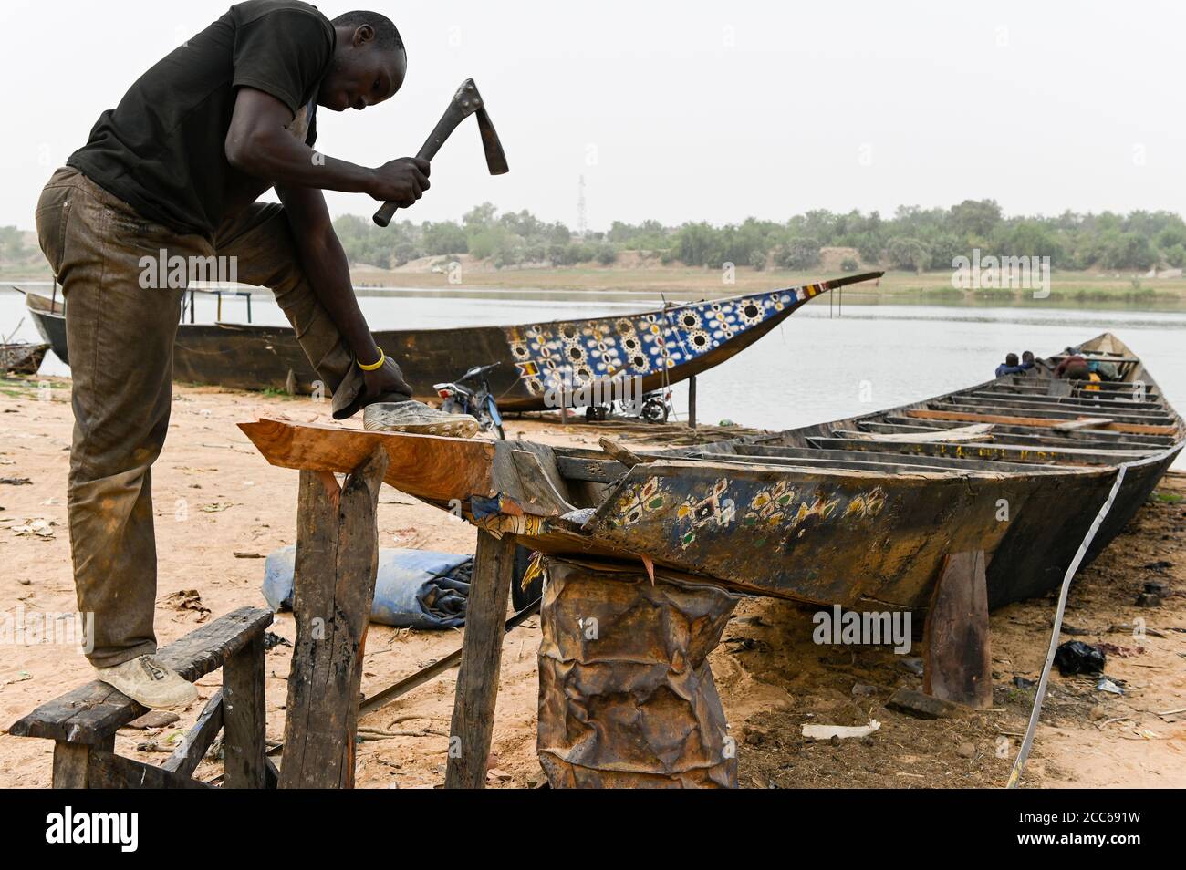 MALI, Kayes, Sengegal river,  boat building of  wooden Pinasse boats at river bank / Senegal Fluss, Bootsbau, Pinasse, Piroge aus Holz mit Bemalung Stock Photo