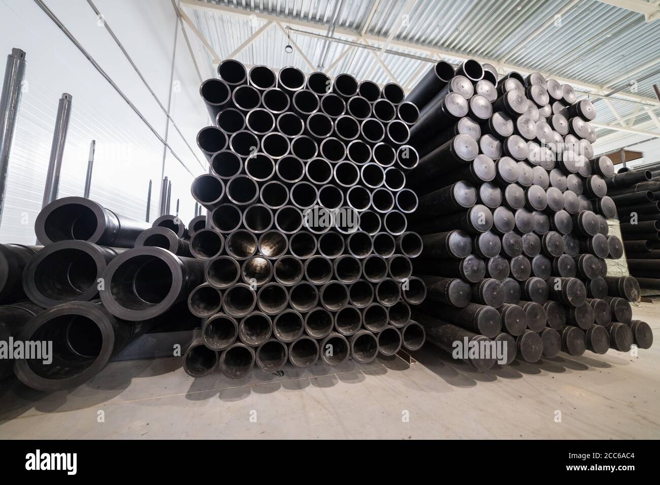 Black plastic tubes in the manufacturing storage. Mid shot Stock Photo