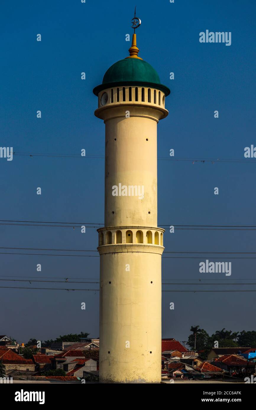 The mosque's green domed minaret is isolated by the blue sky. Stock Photo