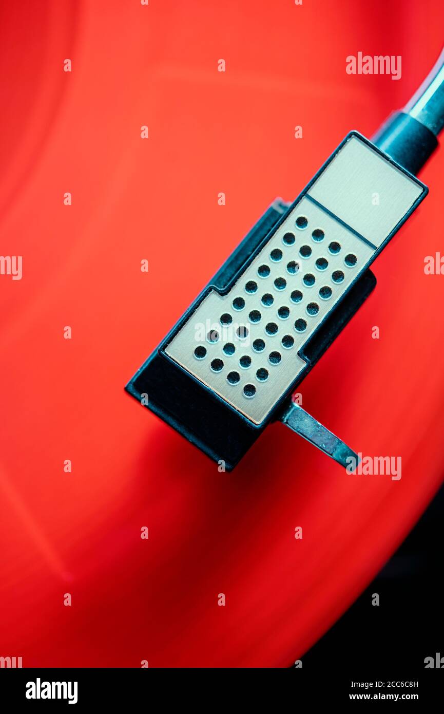 Red vinyl record playing on a turntable Stock Photo