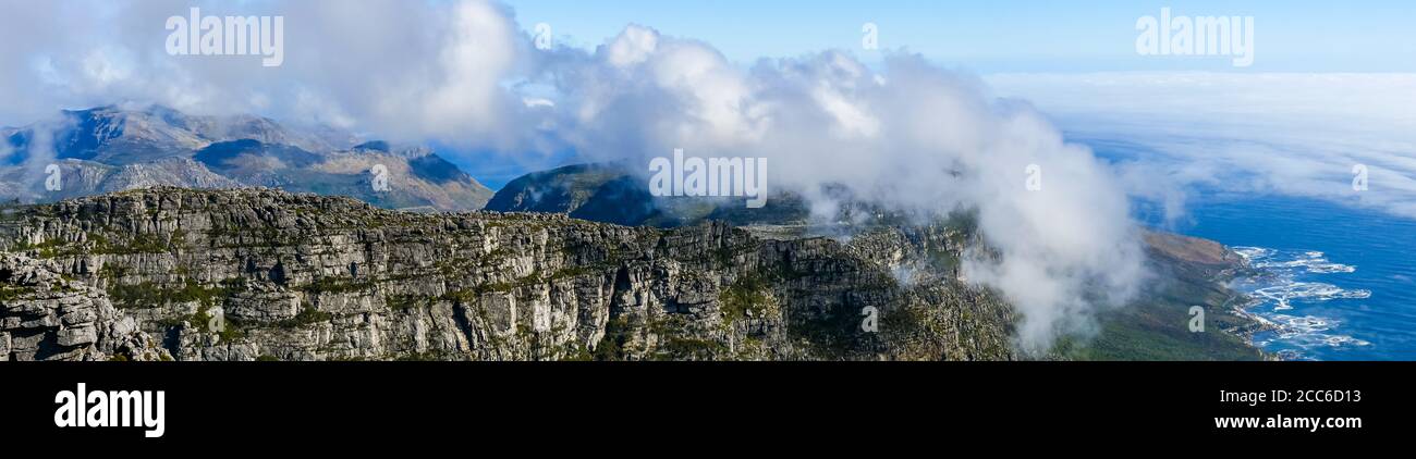 Panoramic view along Table Mountain ridge looking down to sea fog over Atlantic Ocean, Cape Town, South Africa Stock Photo