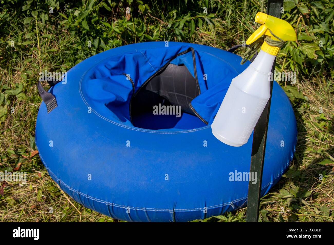 Blue Float River Tube and cleaner spay bottle for disinfecting after use due to COVID-19 Coronavirus Pandemic in summer 2020, sanitary measures Stock Photo