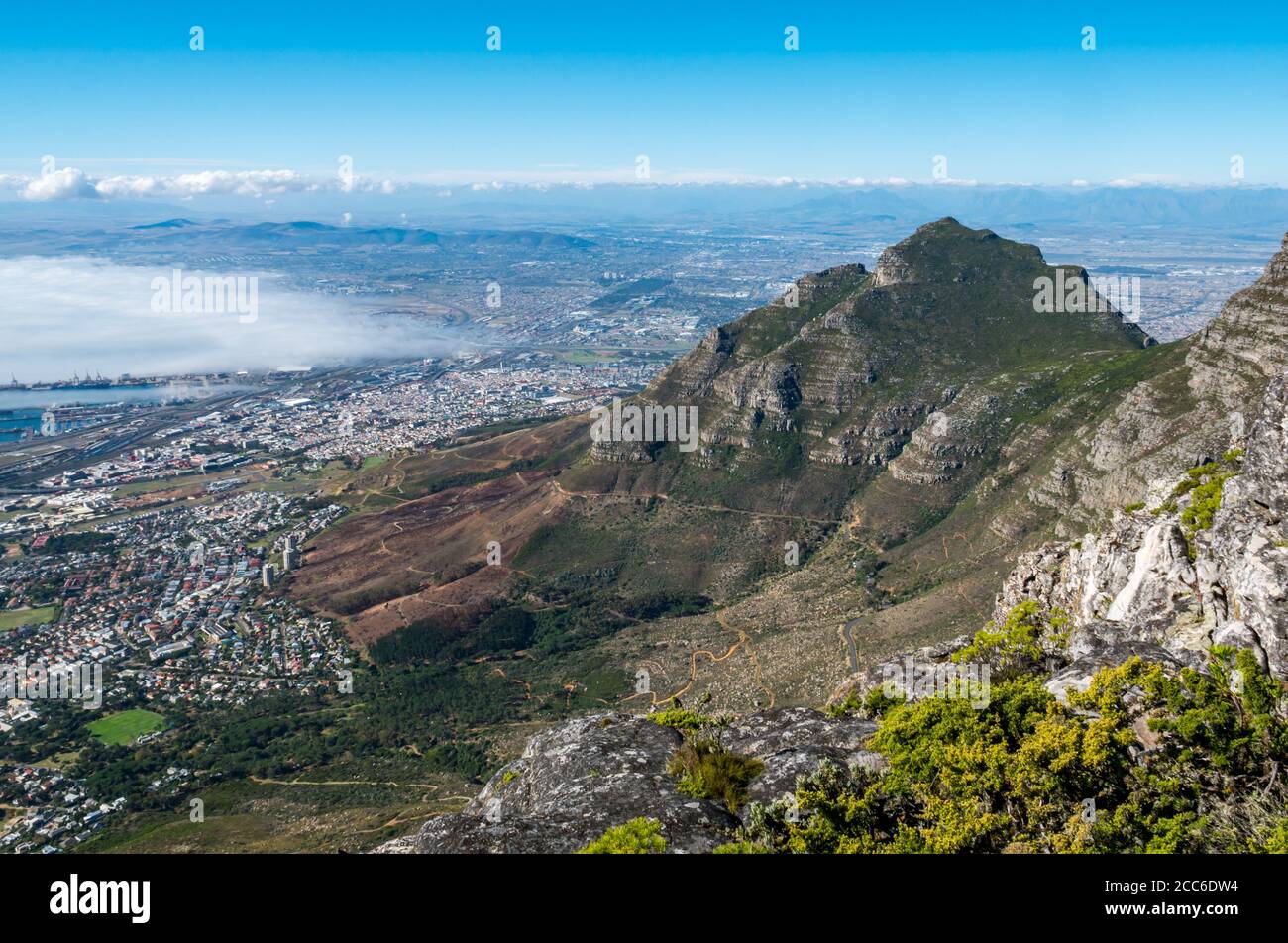 View from Table Mountain of Devil's Peak with sea fog over harbour, Cape Town, South Africa Stock Photo