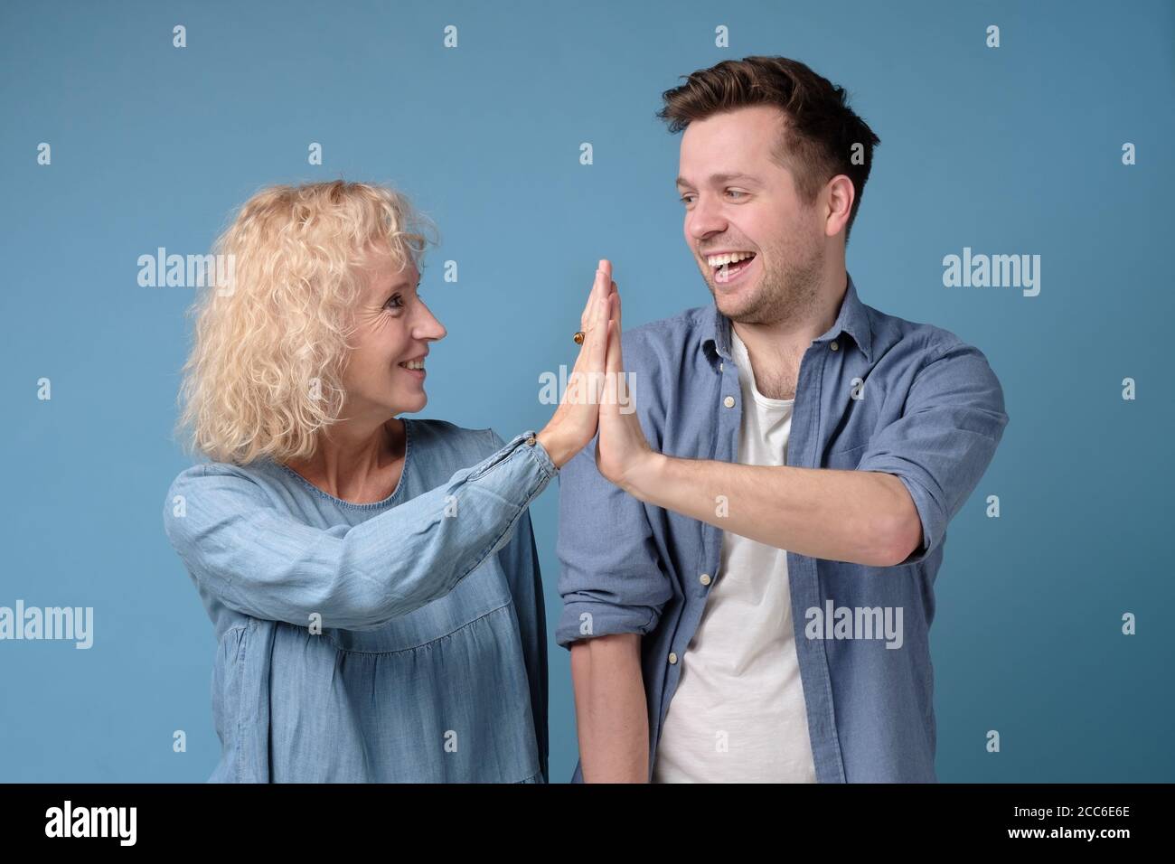 Mother and son giving high five to each other, clapping hands Stock Photo