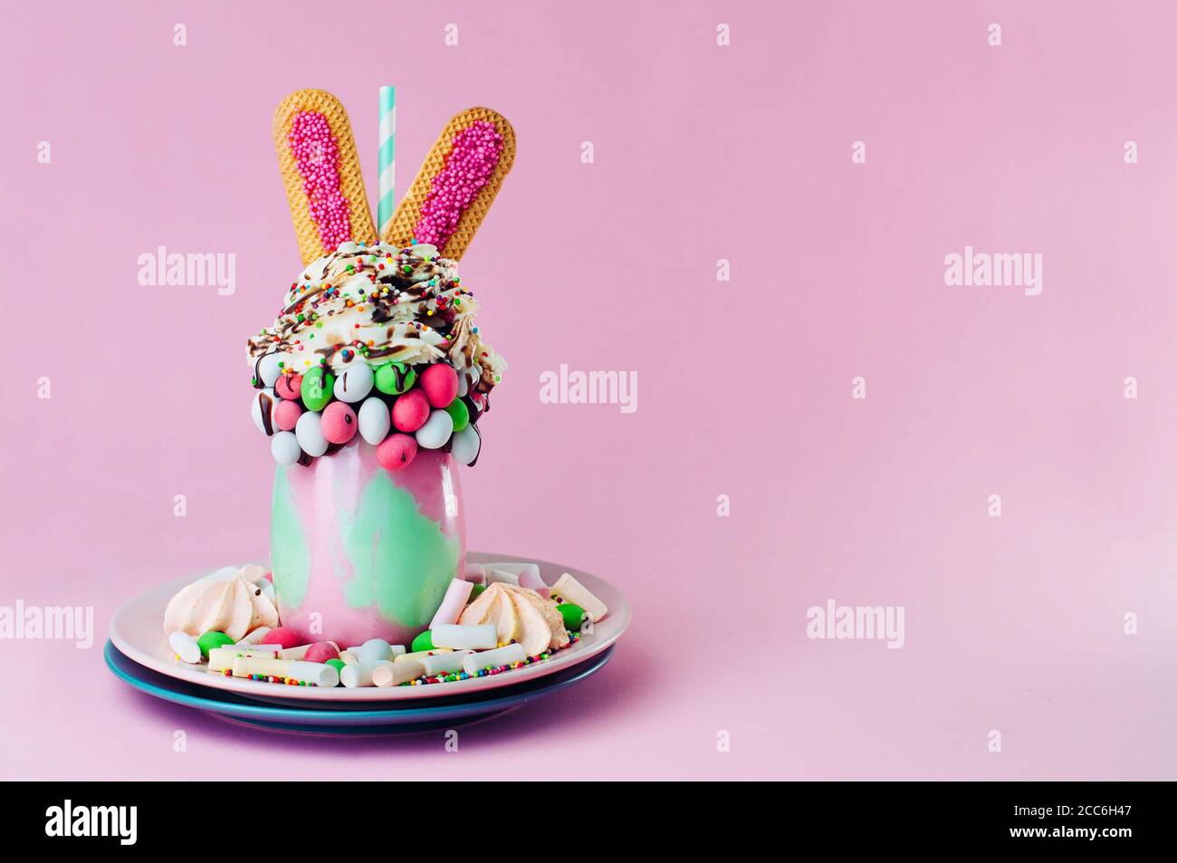 Easter freak shake decorated with bunny ears cookies on pink background with copy space Stock Photo