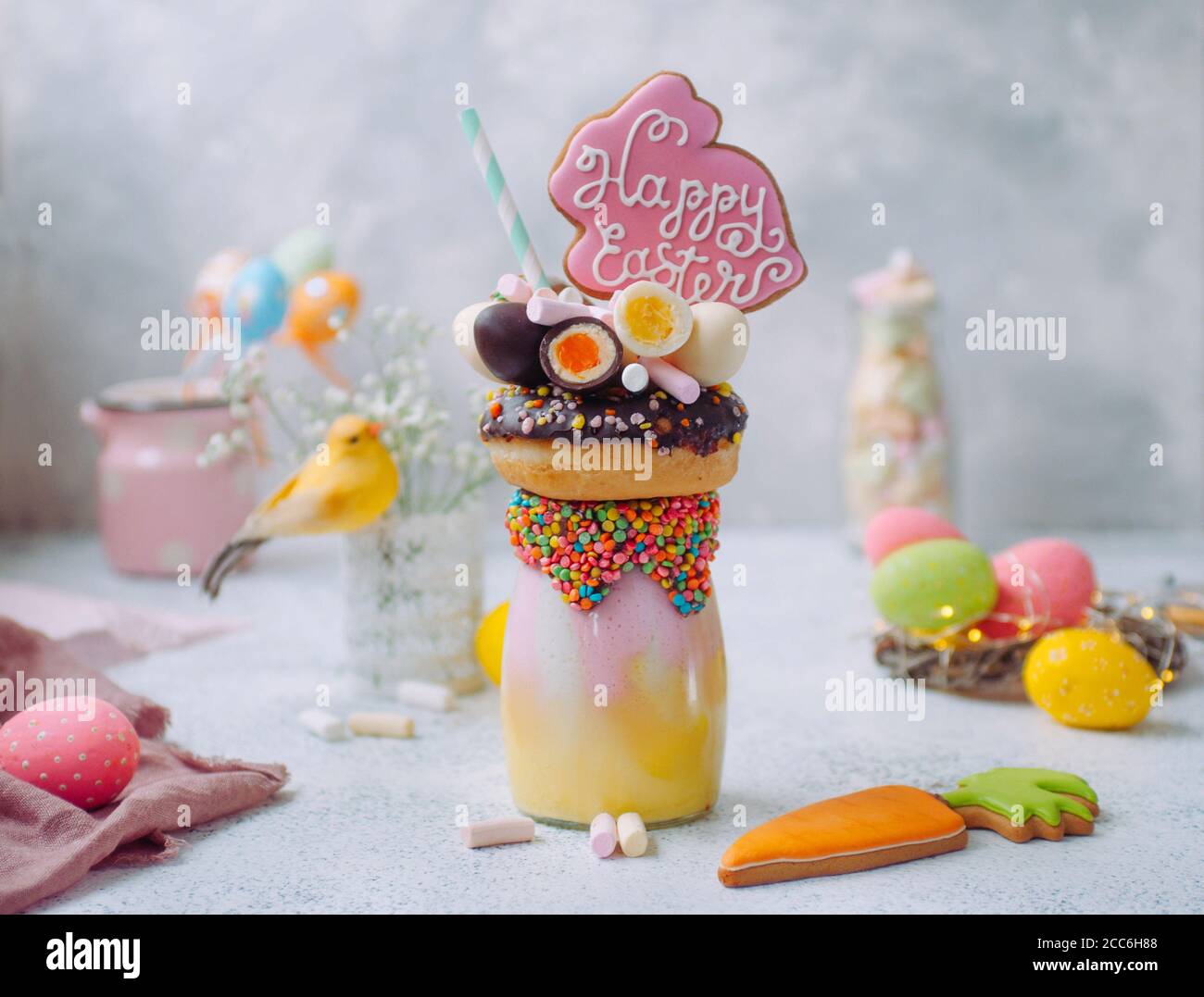 Easter freak shake decorated with Easter bunny gingerbread on the decorated table Stock Photo