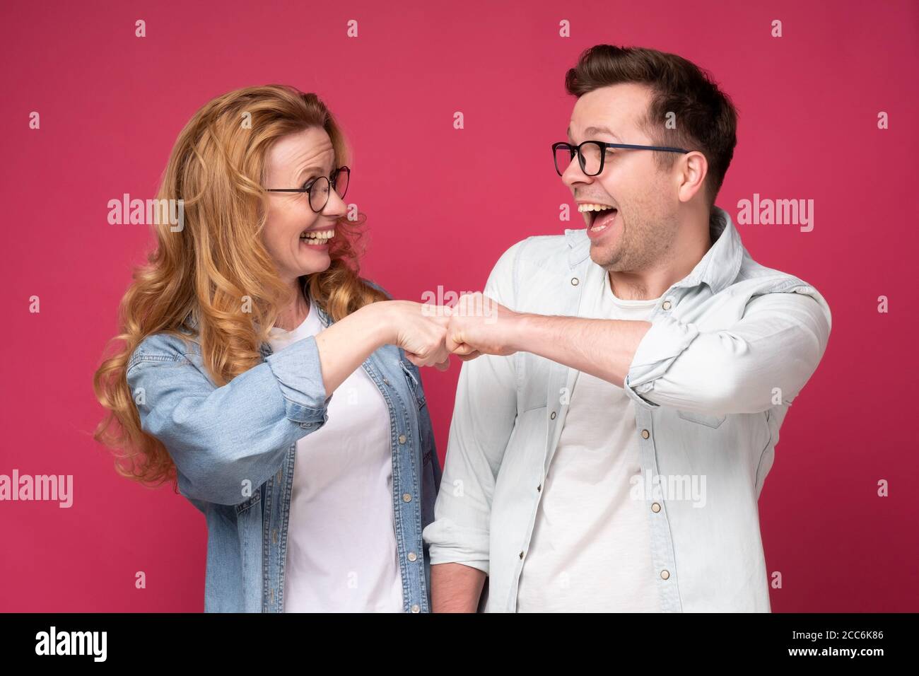 Caucaisan woman and man, friends or coworkers bumping fist Stock Photo
