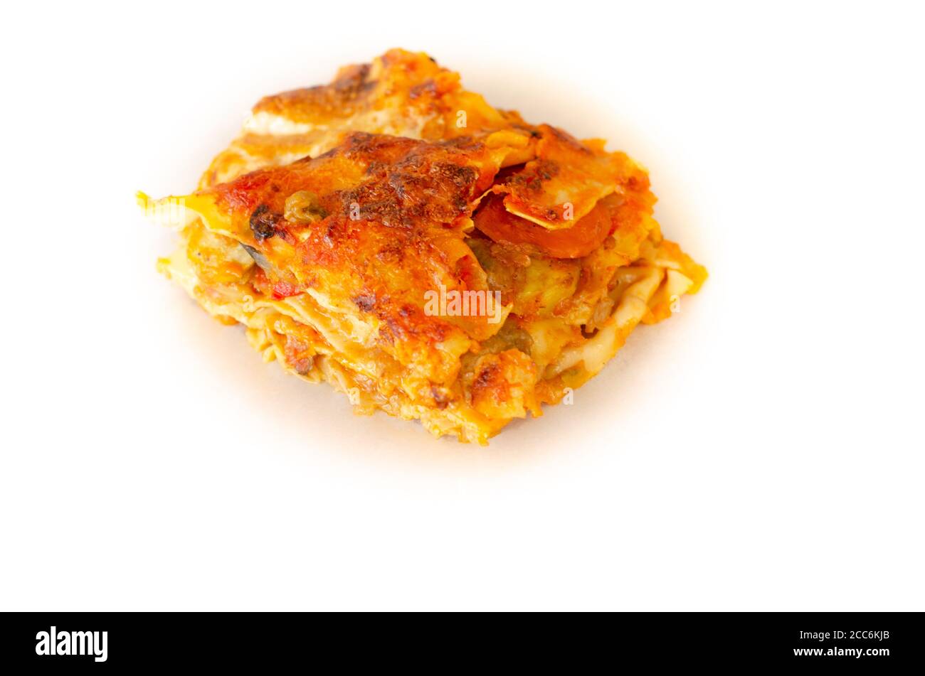 Hand made close up vegetable lasagna on baking cooking paper isolate on white Stock Photo