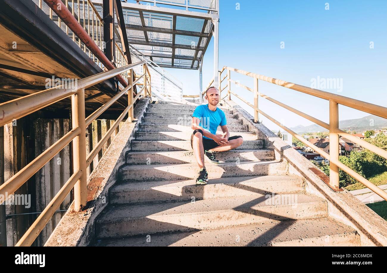 Man sits on stairs after workout set Stock Photo