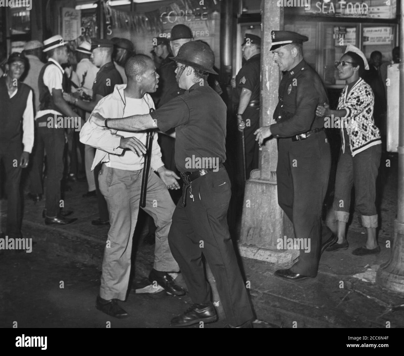 Policemen confront group of People after night of rioting due to fatal shooting of Teen James Powell by Police Officer Lt. Thomas Gilligan, Fulton St. and Nostrand Ave., Brooklyn, New York, USA, Stanley Wolfson, World Telegram & Sun, July 21, 1964 Stock Photo