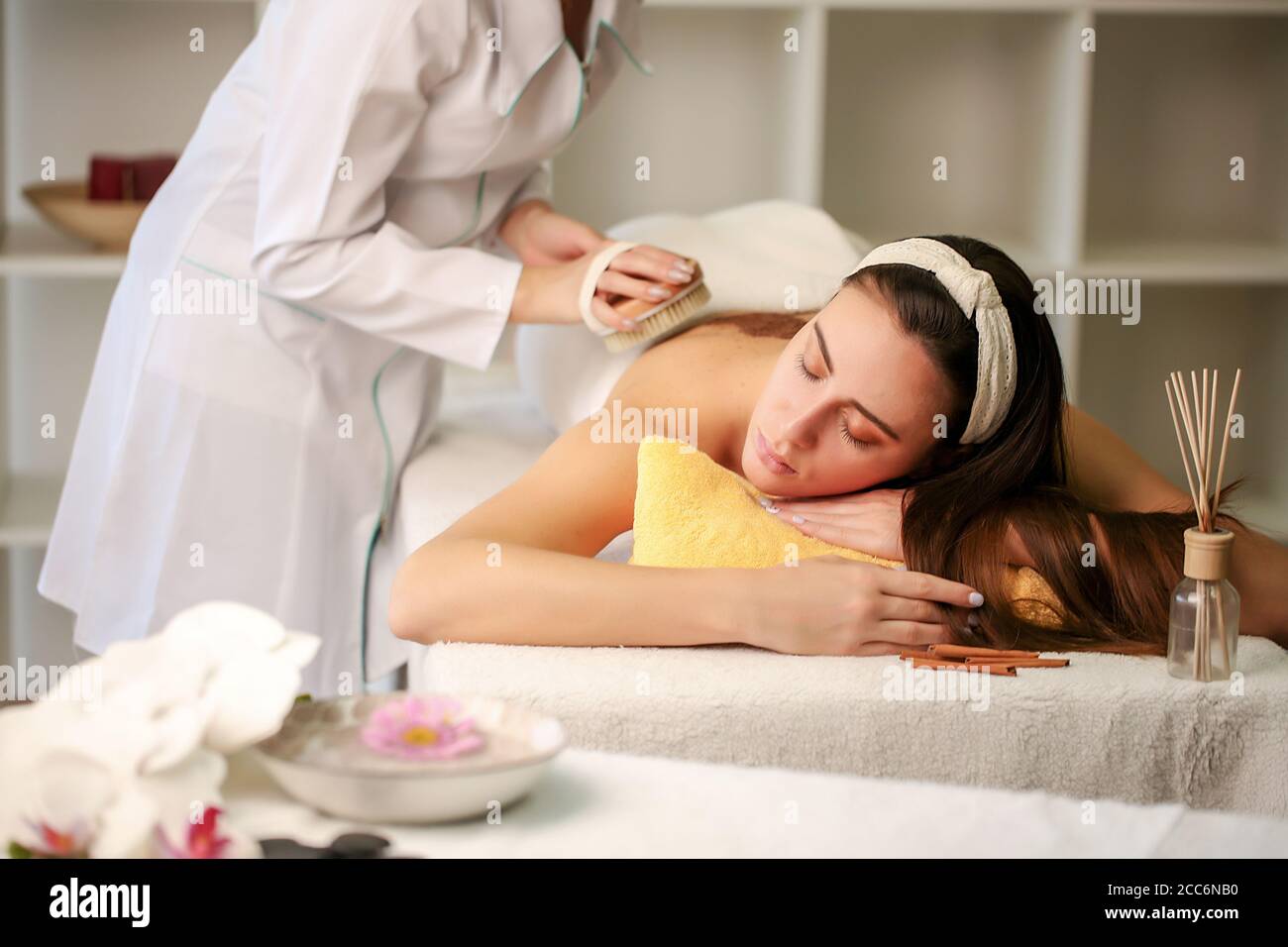 Woman enjoying a salt scrub massage at the health spa Stock Photo