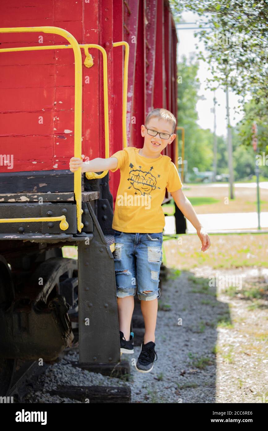 Young boy hanging on Caboose Stock Photo
