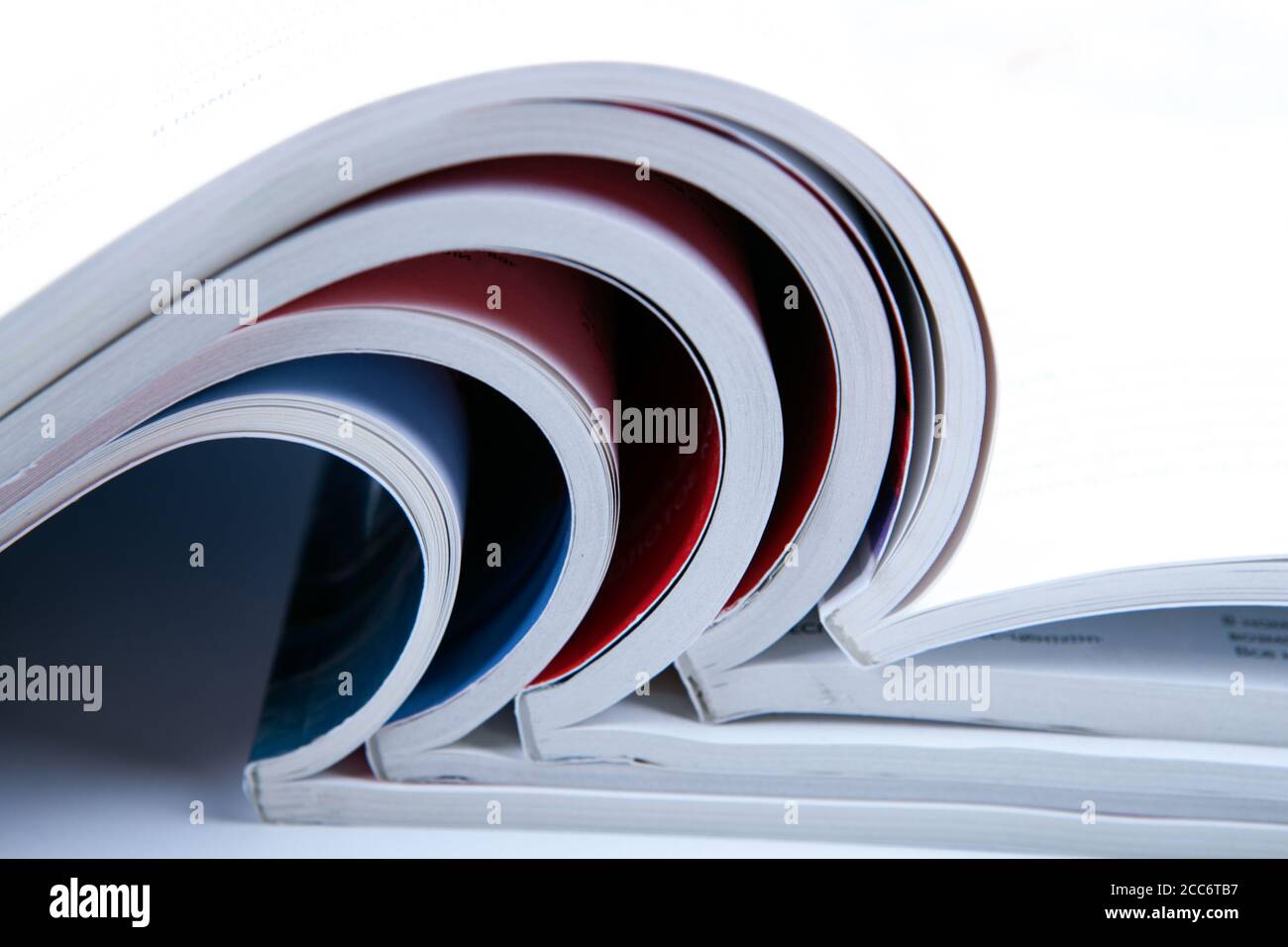 stack of open glossy magazines on white background closeup Stock Photo