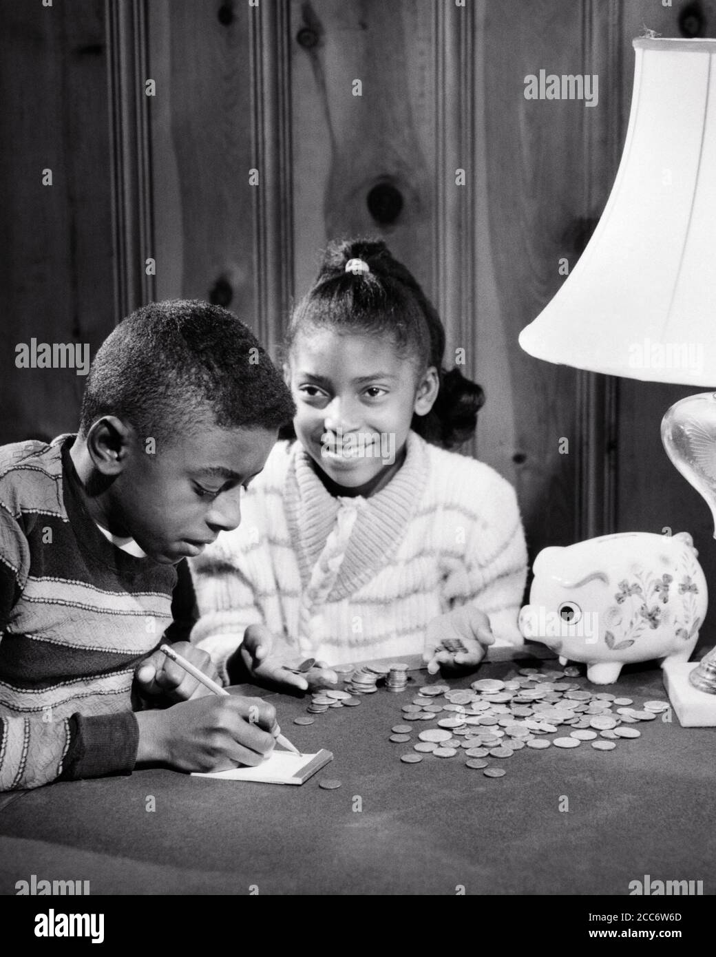 1960s FRUGAL SMILING AFRICAN-AMERICAN BOY GIRL BROTHER SISTER COUNTING MONEY FROM THEIR PIGGY BANK - bj00303 CAM001 HARS JOY LIFESTYLE SATISFACTION FEMALES BROTHERS HOME LIFE FINANCES COPY SPACE FRIENDSHIP HALF-LENGTH MALES SIBLINGS CONFIDENCE SHARE SISTERS B&W GOALS DREAMS HAPPINESS AFRICAN-AMERICANS AFRICAN-AMERICAN CAM001 BLACK ETHNICITY PRIDE SIBLING CONNECTION COOPERATION JUVENILES PRE-TEEN PRE-TEEN BOY PRE-TEEN GIRL TOGETHERNESS BLACK AND WHITE OLD FASHIONED AFRICAN AMERICANS Stock Photo