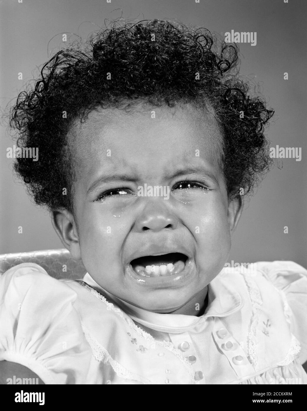 1960s UNHAPPY AFRICAN-AMERICAN BABY GIRL CRYING  - n1975 HAR001 HARS STUDIO SHOT MOODY TEARS HOME LIFE COPY SPACE CRY EXPRESSIONS TROUBLED B&W CONCERNED SADNESS EYE CONTACT WEEPING HEAD AND SHOULDERS AFRICAN-AMERICANS AFRICAN-AMERICAN BLACK ETHNICITY BAWLING MOOD SOBBING CONCEPTUAL GLUM DISAPPOINTED GROWTH JUVENILES MISERABLE BABY GIRL BLACK AND WHITE HAR001 OLD FASHIONED TEETHING AFRICAN AMERICANS Stock Photo