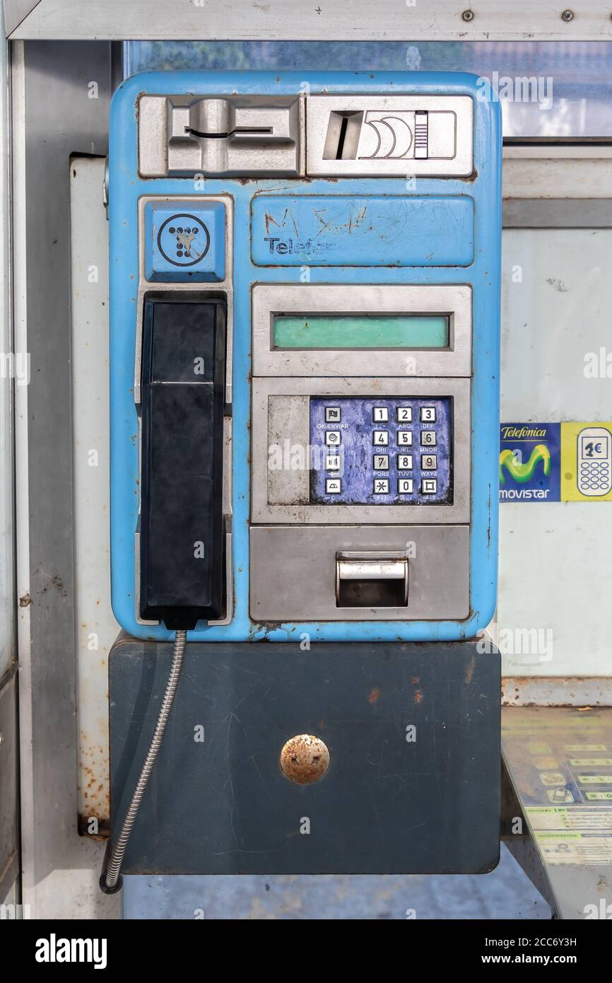 Huelva, Spain - August 16, 2020: Detail of Phone inside booth from Telefonica company in the town of Valverde del Camino. One of old and useless publi Stock Photo
