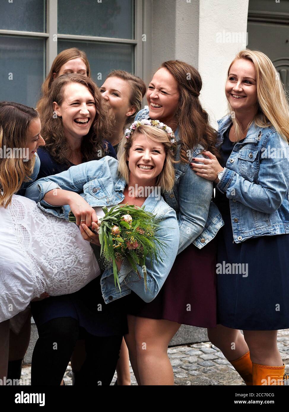 GUMPOLDSKIRCHEN, AUSTRIA - 09/01/2018. Happy caucasian bride among laughing bridesmaids. Stock Photo