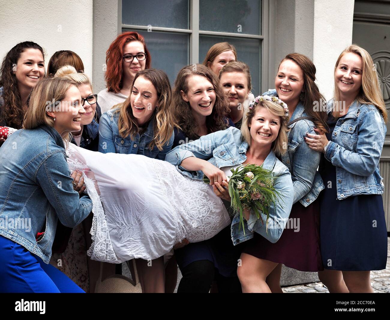 GUMPOLDSKIRCHEN, AUSTRIA - 09/01/2018. Happy caucasian bride among laughing bridesmaids. Stock Photo