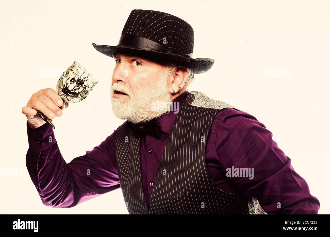 On Halloween night. evil wizard cooking magic potion with spider. mature man magician in witch hat. happy halloween. barman make cocktail for halloween party. halloween holiday costume. Stock Photo