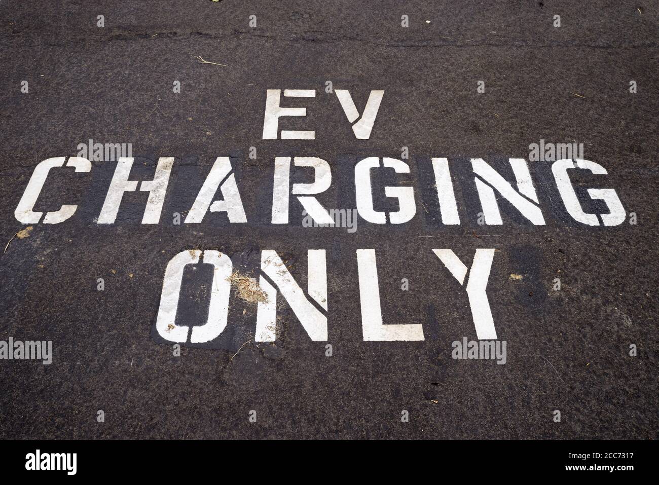 EV charging only in white on the pavement of an electric vehicle charging space Stock Photo