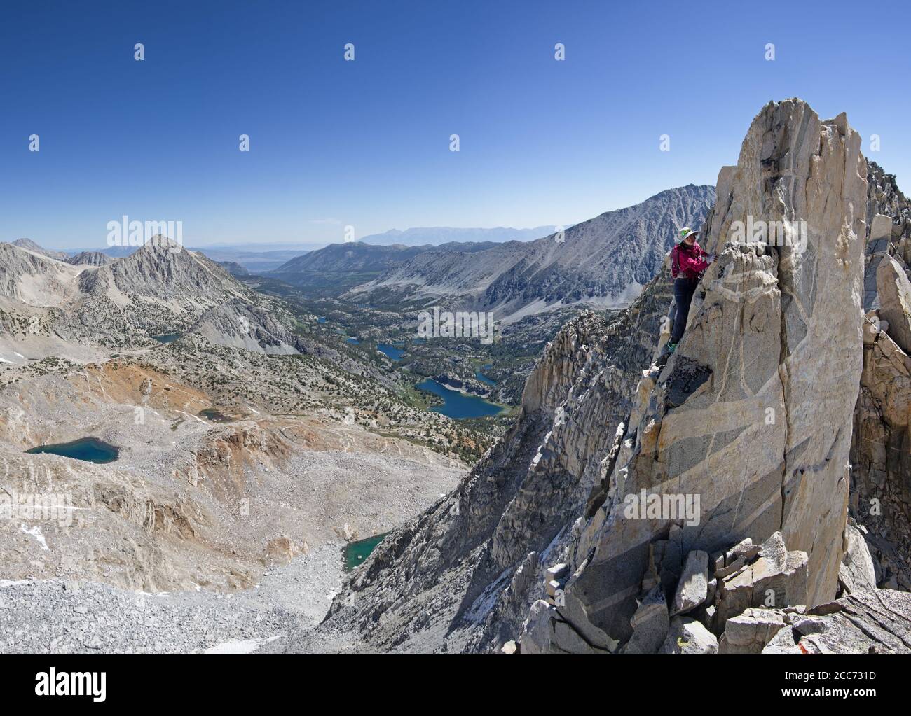 Asian woman climbing on the steep East Ridge of Treasure Peak above the Little Lakes Valley Stock Photo