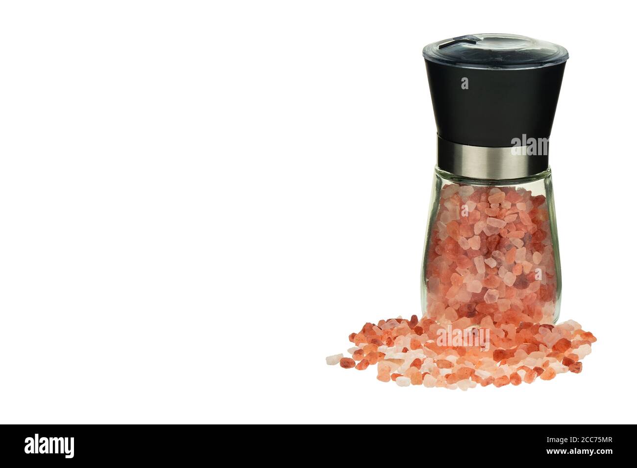 Pink Himalayan salt crystals in a glass grinder. Himalayan pink salt in mill isolated on white background. Stock Photo