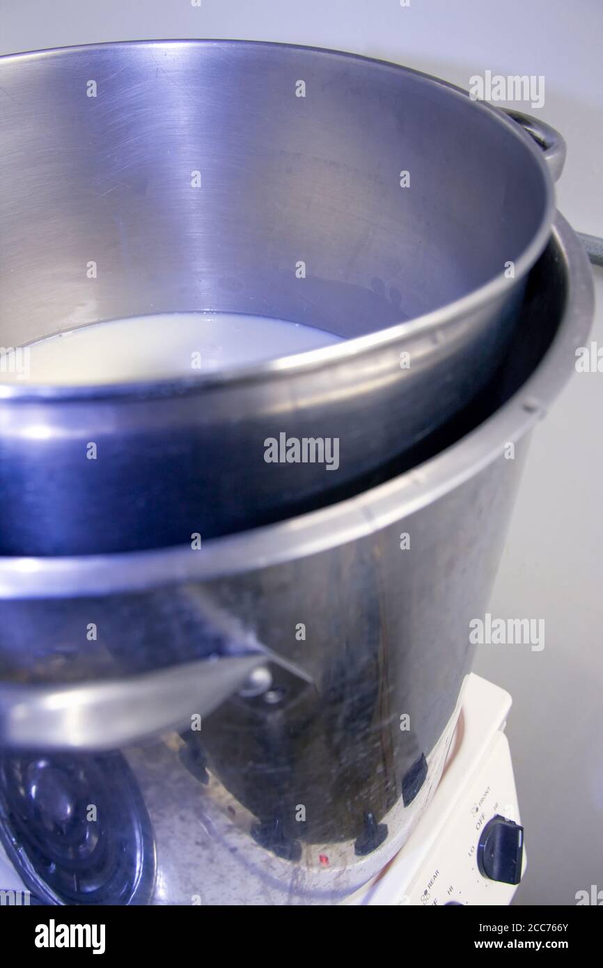 Heating the milk in large double boiler pots in Fall City, Washington, USA Stock Photo