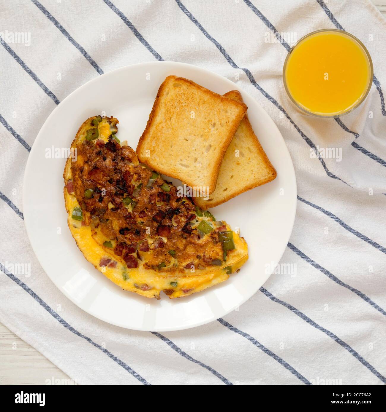 Homemade Denver Omelette on a white plate on cloth, overhead view. Flat lay, top view, from above. Stock Photo