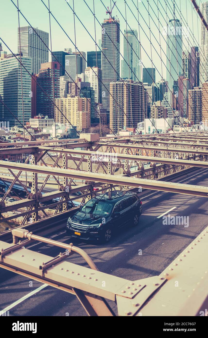 A Car Speeding Across Brooklyn Bridge With The Manhattan Skyline In The Background Stock Photo