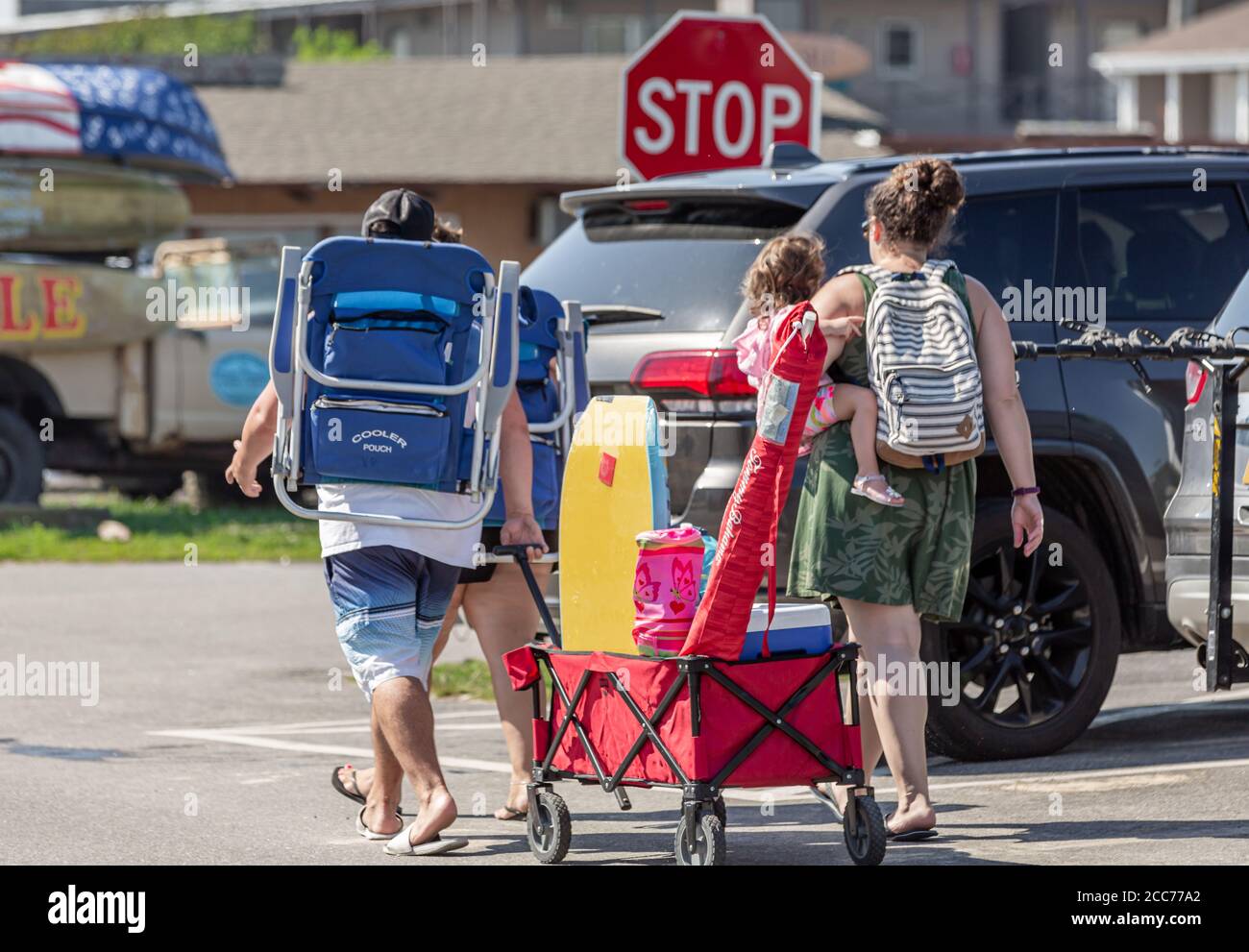Family of four headed to the ocean beach with chairs, umbrellas and toys, Montauk, NY Stock Photo
