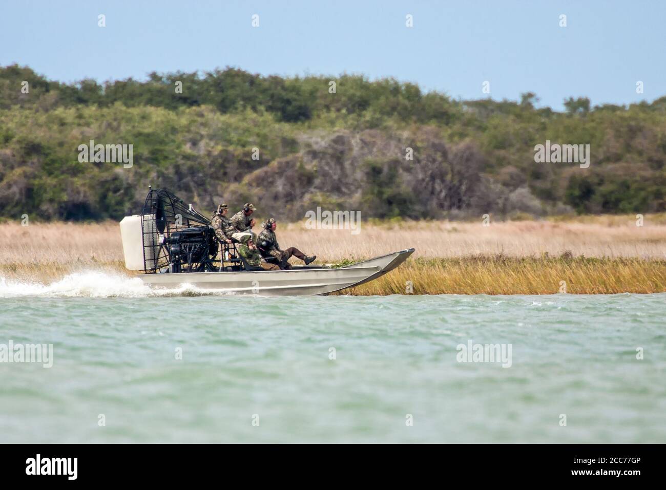 Duck hunters wearing camouflage gear in an airboat in Aransas National Wildlife Refuge on the Gulf Coast of Texas, USA Stock Photo