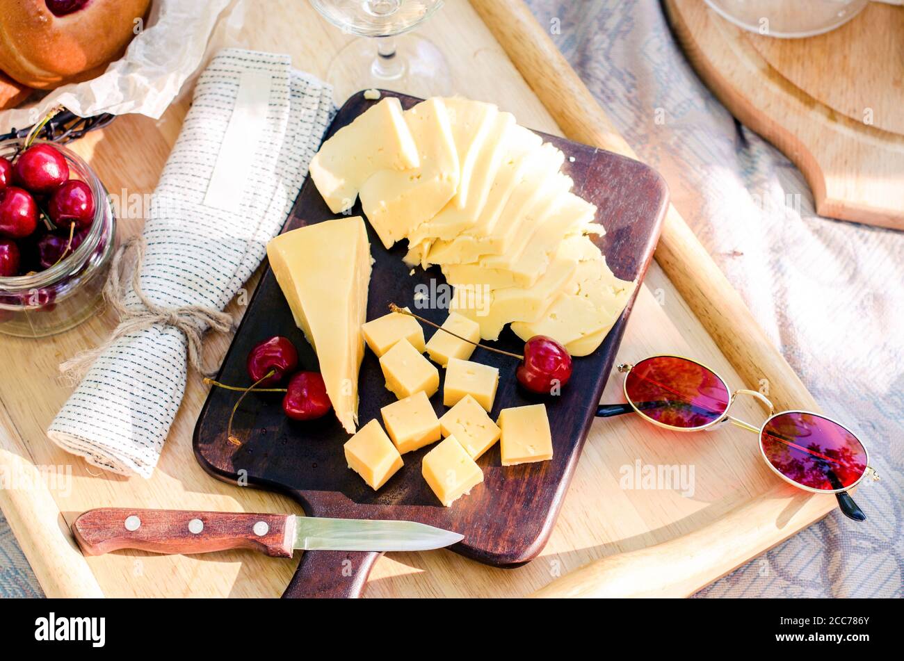 French style romantic picnic setting. Set of cheese, cherry. Blanket