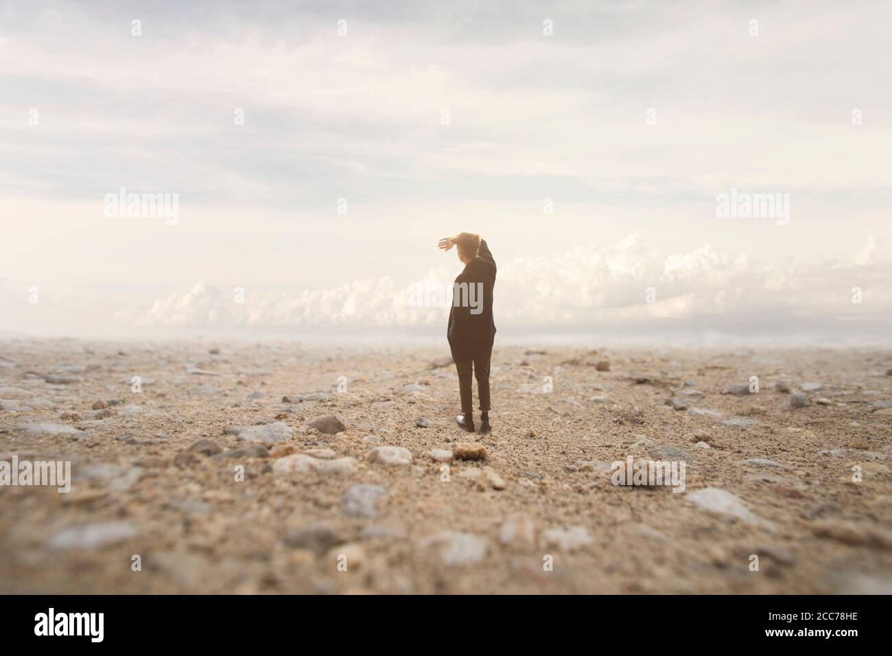 solitary man looks at the infinite in a surreal and spectacular landscape Stock Photo
