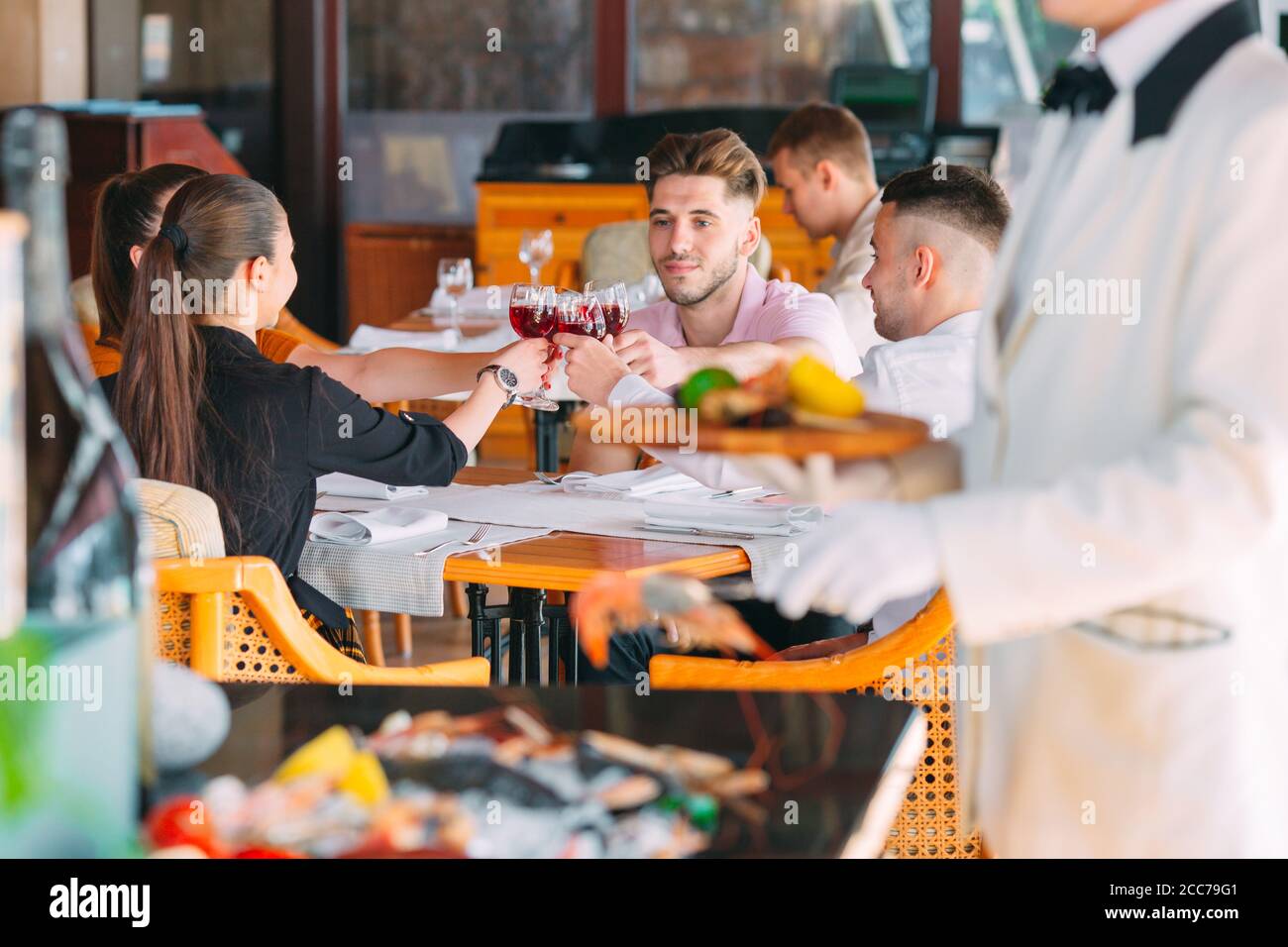 friends-drink-wine-on-the-terrace-of-the-restaurant-2CC79G1.jpg