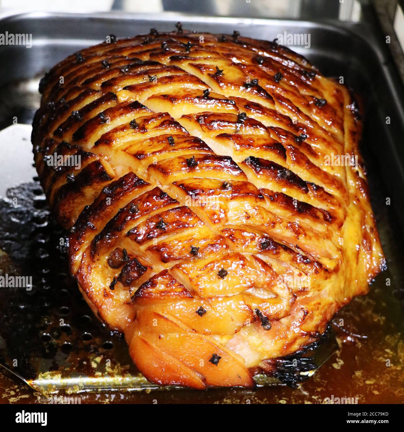 honey glazed gammon ham with traditional herbs and spicesin a roasting tray Stock Photo