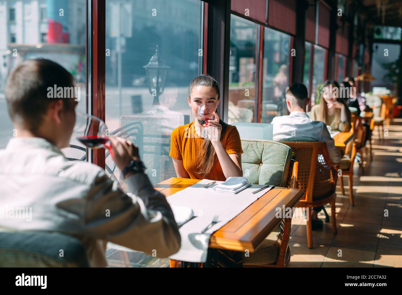 A young couple drinking wine in a restaurant near the window Stock ...